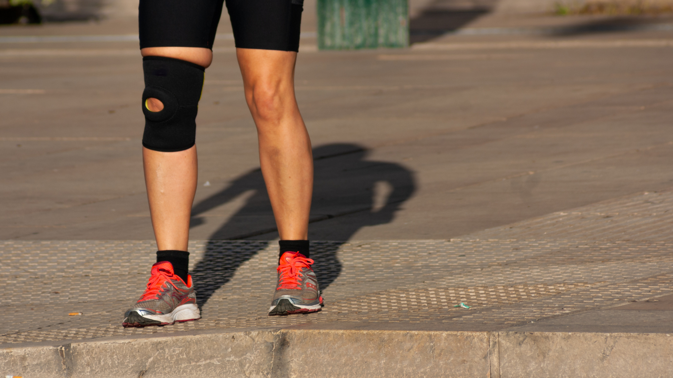 Person running with patellofemoral pain syndrome, with a knee brace on.