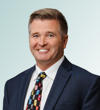 man smiling, wearing a suit and tie