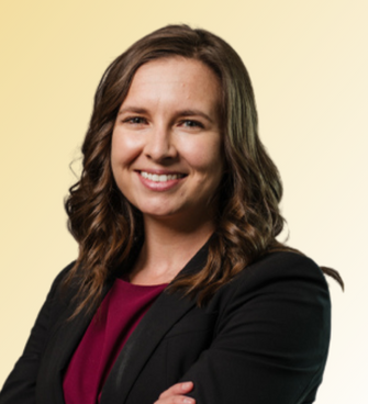 woman smiling, wearing a maroon shirt and black suit jacket