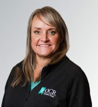 woman smiling, wearing a black jacket and a medical scrubs