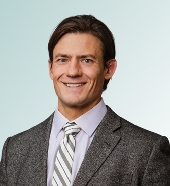 man smiling, wearing a suit and tie