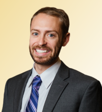 man smiling, wearing a suit and tie