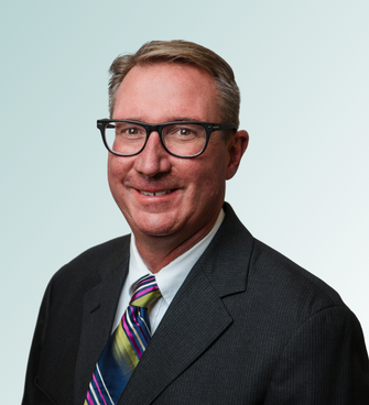 man smiling, wearing a suit