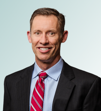 man smiling, wearing a suit and tie