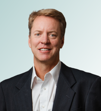 Robert FitzGibbons, MD, a man with short, light brown hair and a light complexion, is smiling. He is wearing a black blazer over a white dress shirt. The background is a gradient of light blue and white.