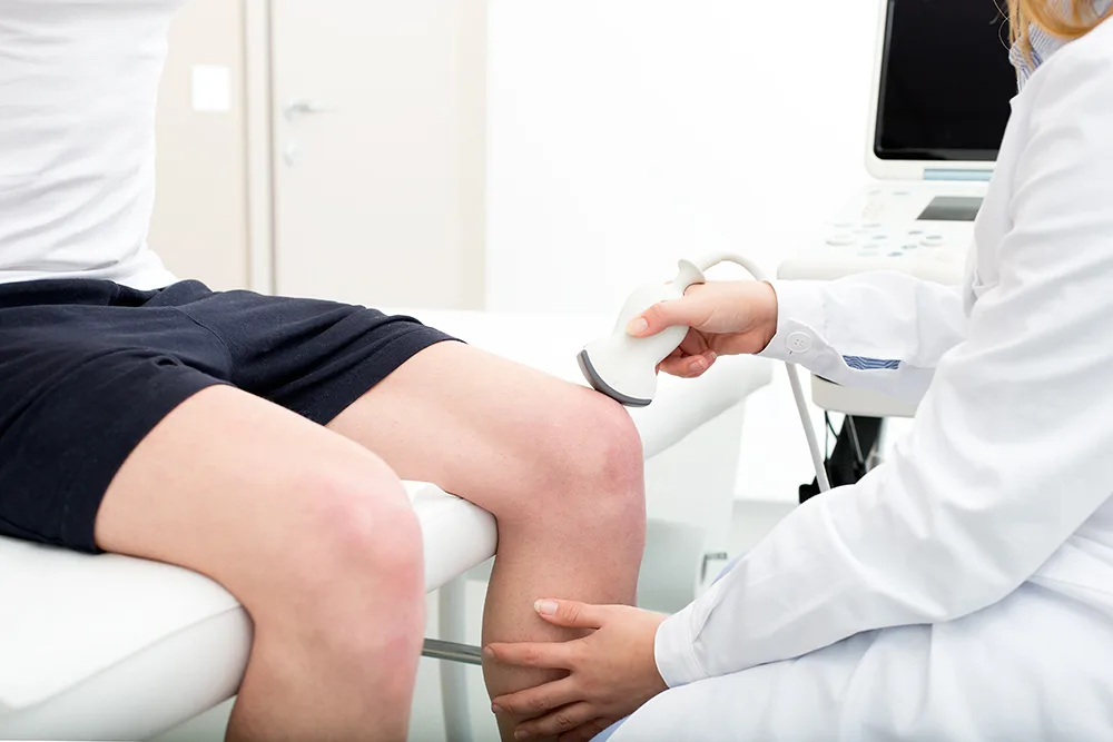 doctor using an ultrasound on a patient's knee