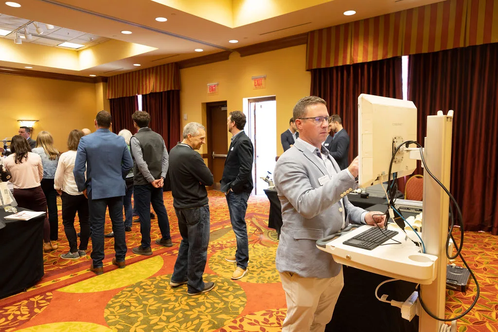 group of people at an event, one using a computer