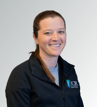 woman smiling, wearing a black jacket and a medical scrubs