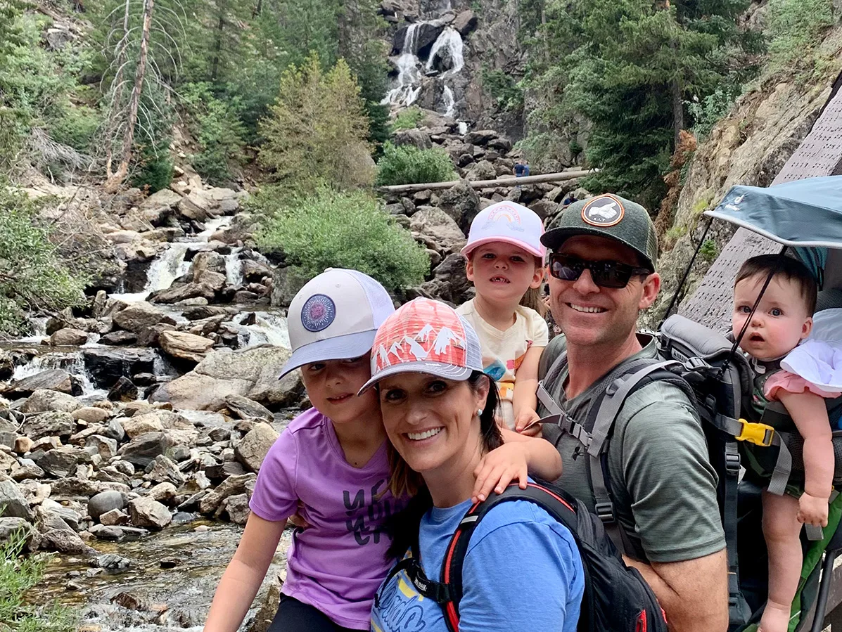 a family of 5 on a hike with rocks in the background