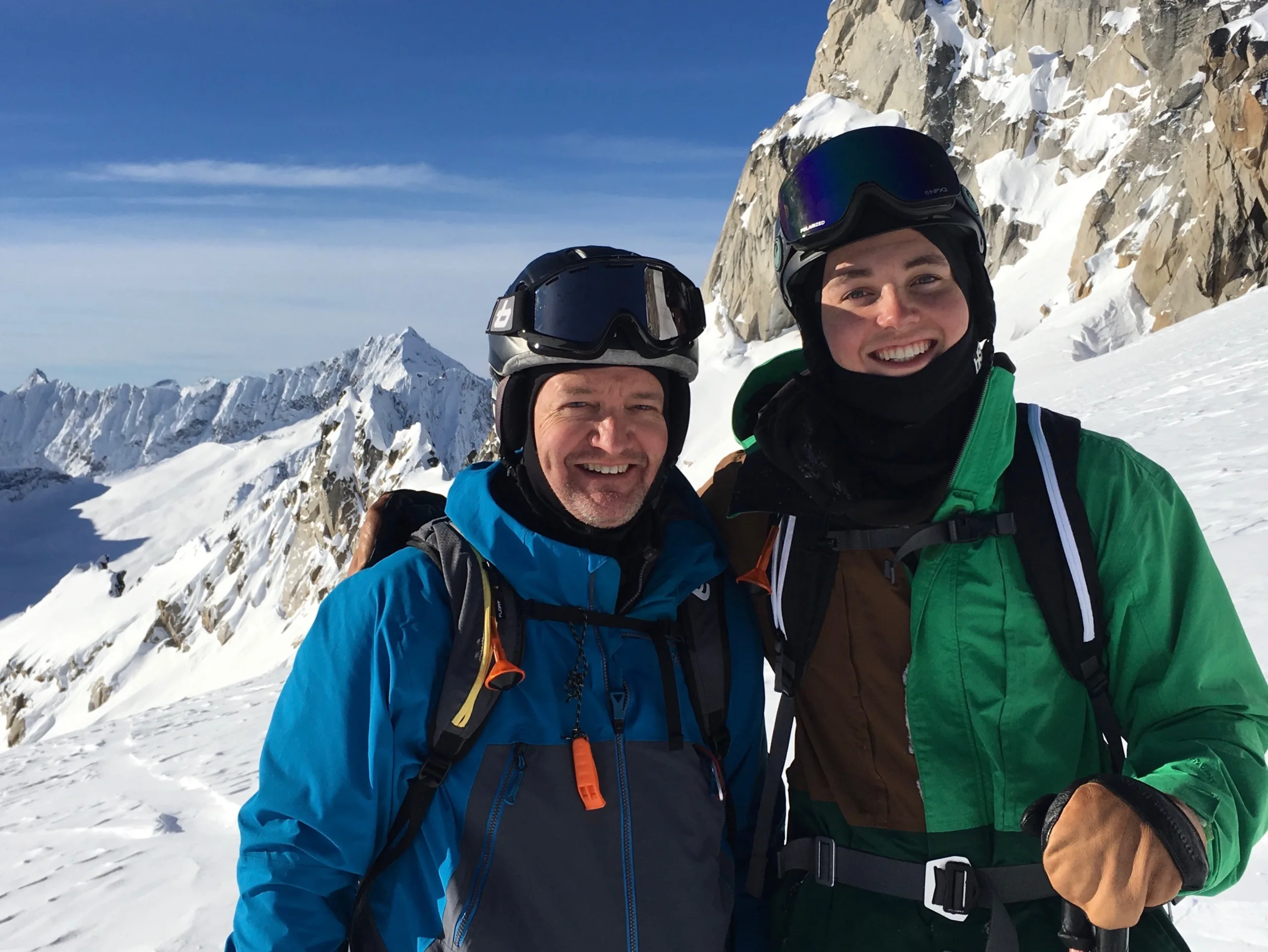 two people standing in snow gear