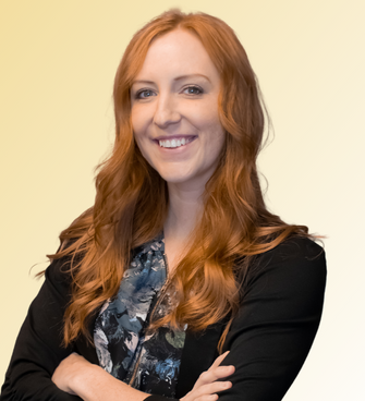 woman smiling, wearing a floral shirt and black cardigan