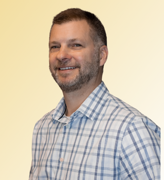 man smiling, wearing plaid shirt