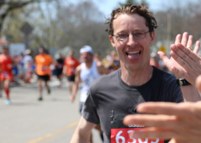 a man high fiving someone as he finishes a race