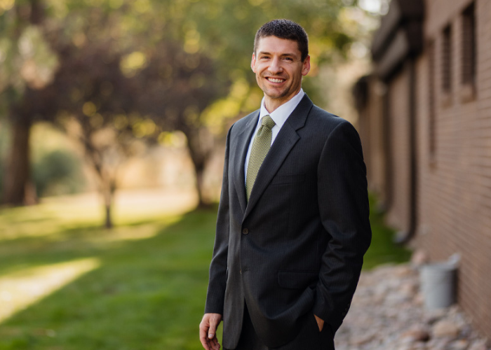 Dr. Ebel standing outside with trees behind him