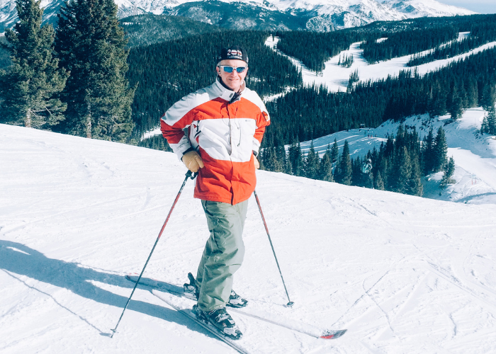 A man in an orange jacket on skis