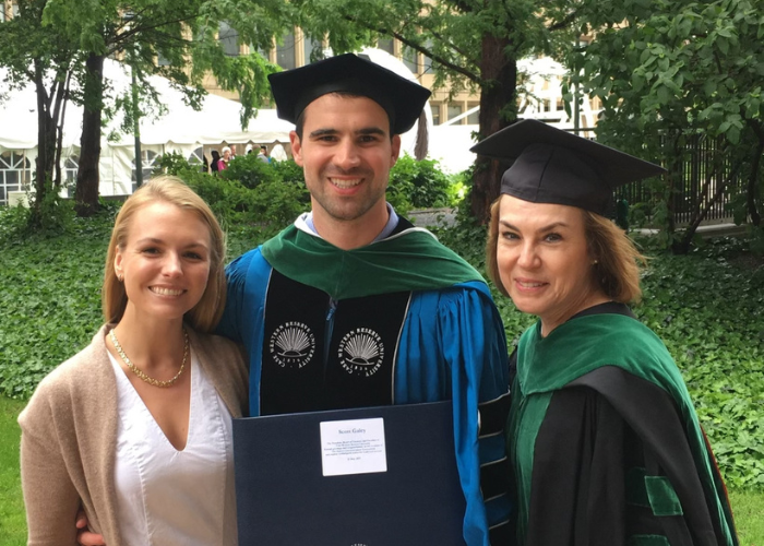 A man and two women standing in graduation gear