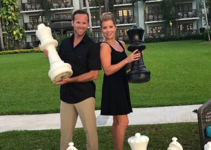 A man and a woman holding chess pieces