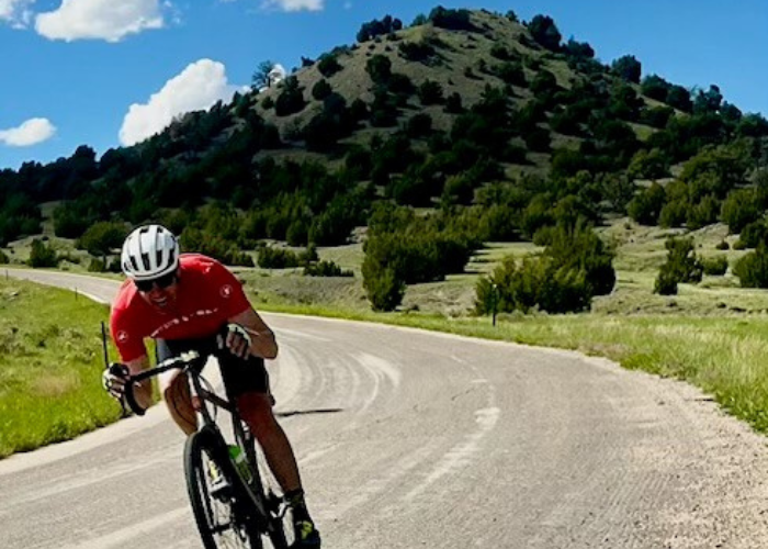 man on a bike with a green mountain behind him