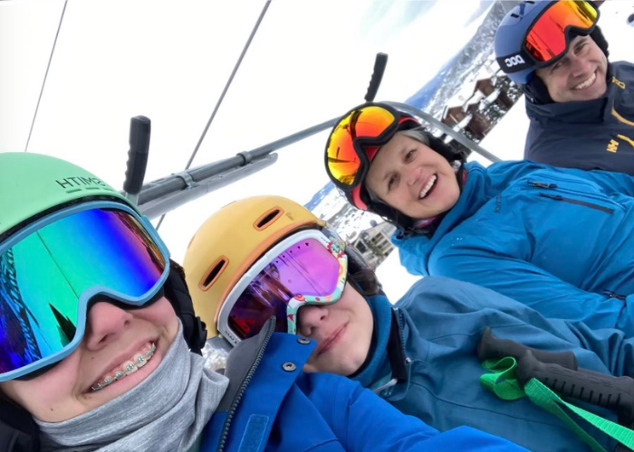 A selfie of a family of 4 on a ski lift 