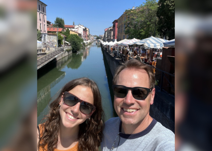 a man and woman in front of a river