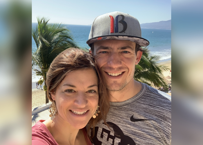 A man and a woman taking a selfie on a beach