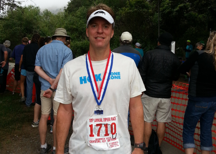 Man after running a race with a medal around his neck