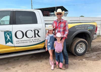 man wearing a cowboy hat, two young girls wearing cowboy hats