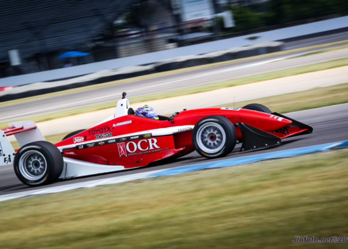 A red and white race car with the number 17 is speeding down a track.