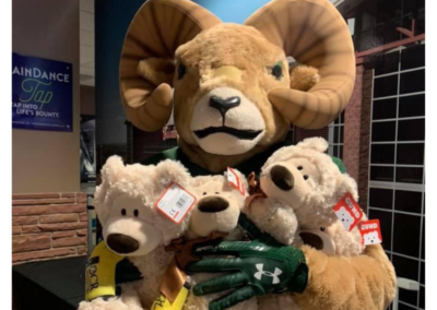 a mascot holding 3 teddy bears