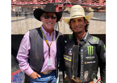 two men standing in vests and cowboy hats