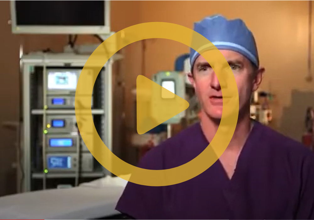 Dr. FitzGibbons in scrubs in a medical room wiht a play button in the forefront