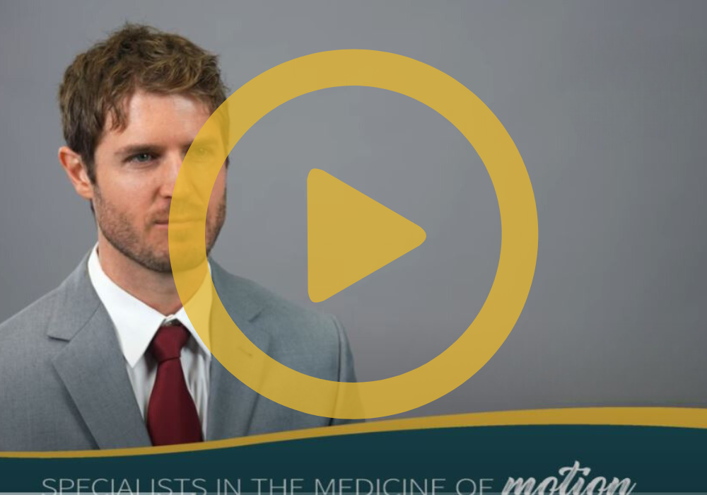 An image of Dr. Alexander with a yellow play button overlay