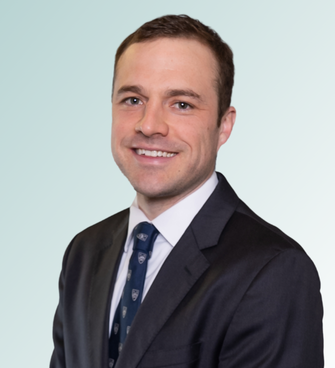 Dr. Daniel Johnson stands in front of a blue gradient background